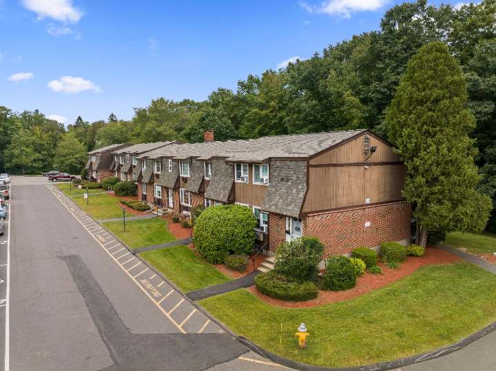 End of a residential building with shrubs and lawn