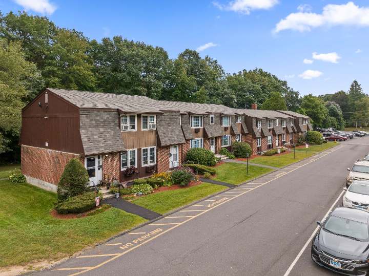 Brick and shingle residences with landscaped front gardens along the main drive