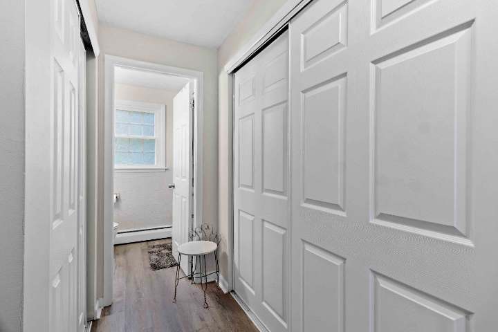 Hallway with double closets leading to the bathroom